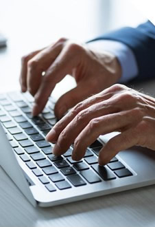 man typing on a laptop